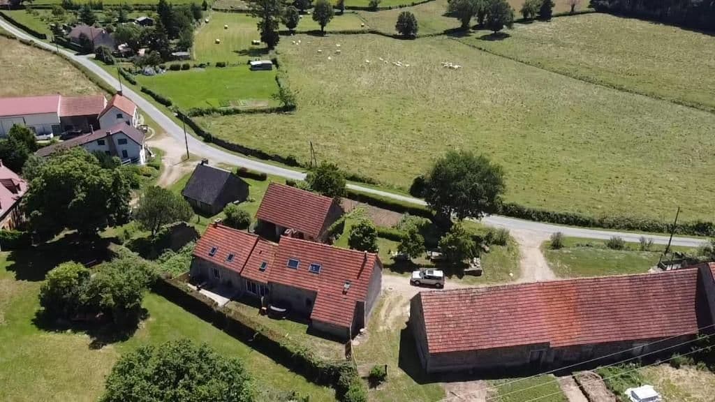 Vue aérienne rapprochée de la ferme et du pré de camping