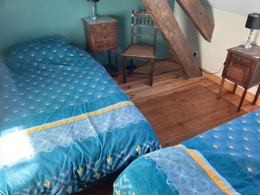 Chambre à deux lits simples sous les poutres apparentes